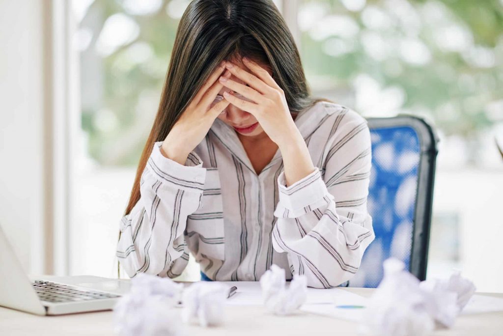 Stressed woman unable to write paper